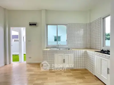 Bright and airy kitchen with tiled backsplash and open layout, featuring a gas stove and ample natural light.