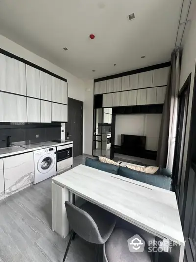 Modern open-layout kitchen with sleek cabinetry and integrated appliances in a stylish apartment.