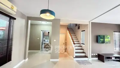 Spacious modern living room with staircase and natural light, perfect for family gatherings.