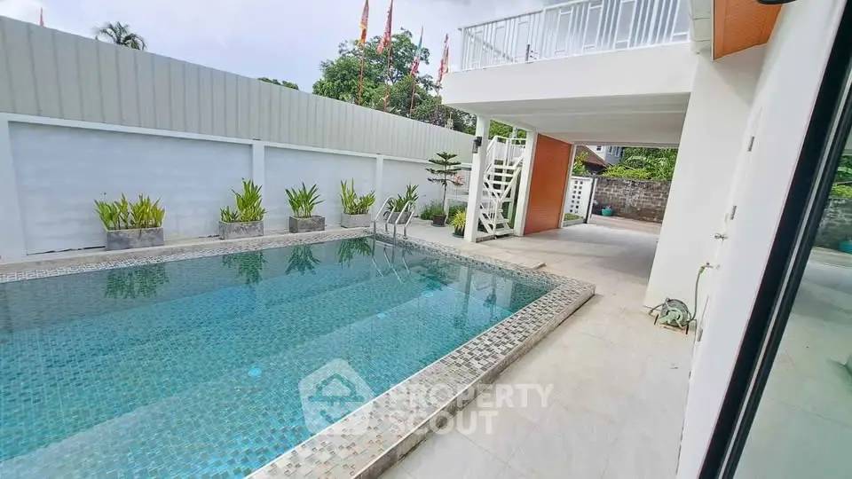 Modern outdoor pool area with stylish design and lush greenery