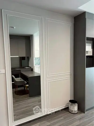 Modern study room with sleek desk and large mirror enhancing space.