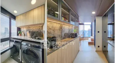 Modern kitchen with sleek appliances and stunning city view, featuring open layout and elegant cabinetry.