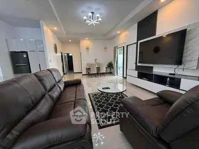 Spacious modern living room with leather sofas and wall-mounted TV, perfect for family gatherings.
