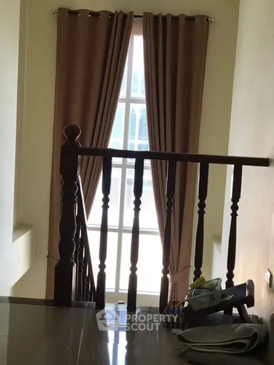 Cozy stairway with elegant curtains and polished wooden railing