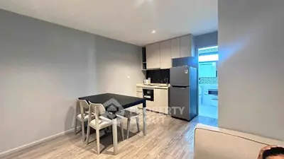 Modern kitchen with dining area featuring sleek appliances and minimalist design.