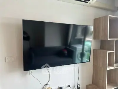 Modern living room with wall-mounted TV and stylish wooden shelves