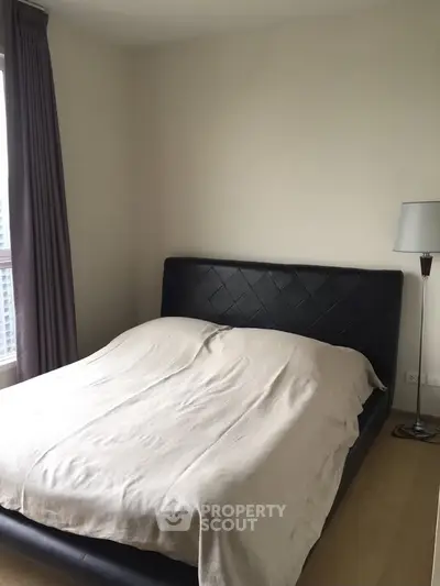 Cozy bedroom with modern bed and natural light in a stylish apartment.