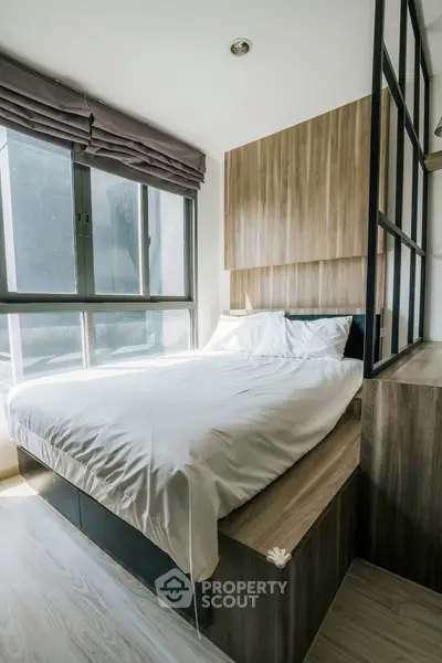 Modern cozy bedroom with large window and stylish wood paneling