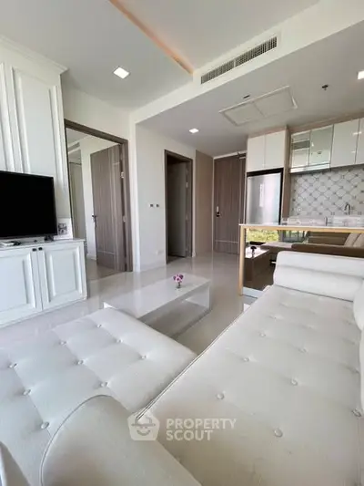 Modern living room with white sofa and open kitchen in stylish apartment