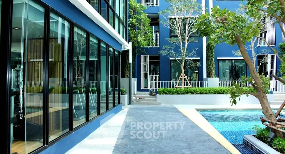 Modern apartment building with pool and lush greenery, offering a serene and luxurious lifestyle.
