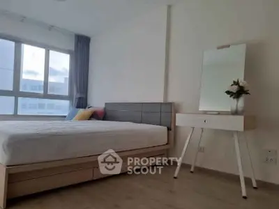 Modern bedroom with stylish bed and elegant vanity in bright natural light.