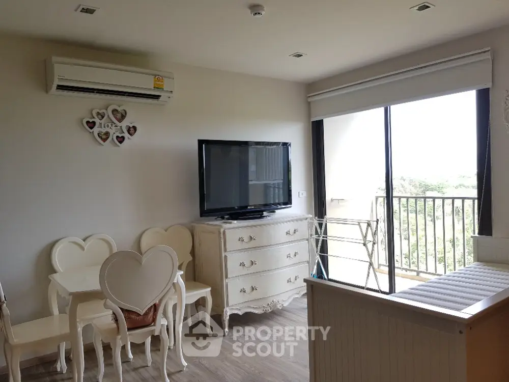 Charming living room with heart-themed decor and balcony view