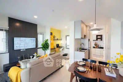 Modern open-plan living room and kitchen with stylish decor and ample natural light.