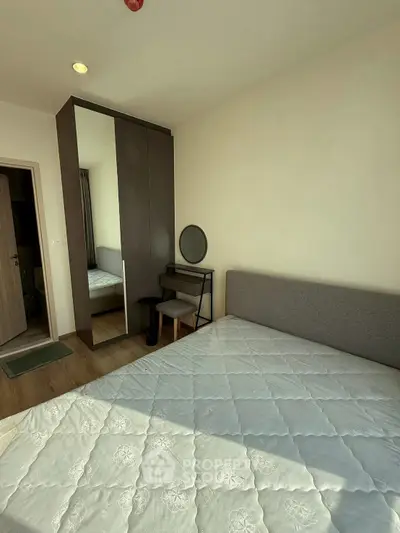 Cozy bedroom with modern furniture and ample natural light, featuring a stylish wardrobe and dressing table.