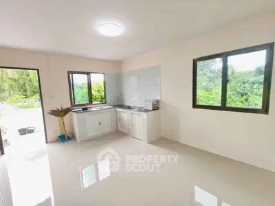 Bright kitchen with large windows and scenic greenery view