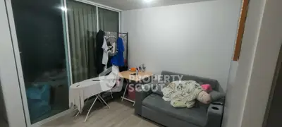 Cozy living room with sliding glass doors and compact furniture setup.