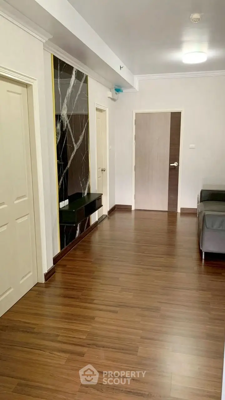 Spacious modern living area with elegant wood flooring and stylish decor.