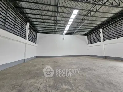 Spacious industrial warehouse with high ceilings and ample natural light.