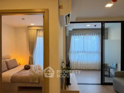 Modern apartment interior with cozy bedroom and spacious living area, featuring elegant curtains and warm lighting.