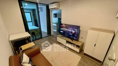 Modern living room with sleek furniture and open layout, featuring a cozy sofa and large TV for entertainment.