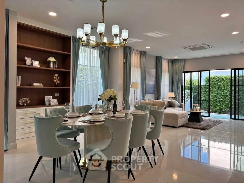 Elegant open-plan living and dining area with modern decor and pool view.