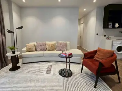 Stylish modern living room with cozy seating and washing machine in corner.