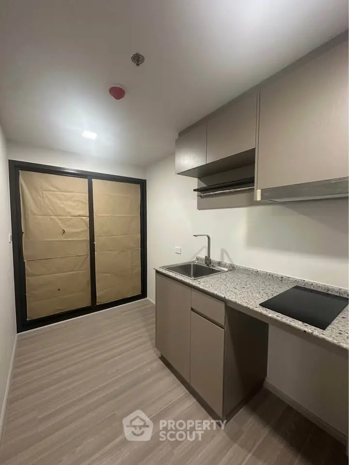 Modern kitchen with sleek cabinetry and granite countertops in a compact layout.