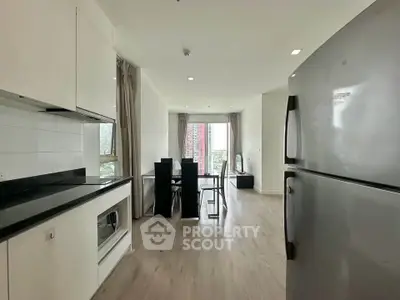 Modern open-plan kitchen and dining area with sleek appliances and bright natural light.