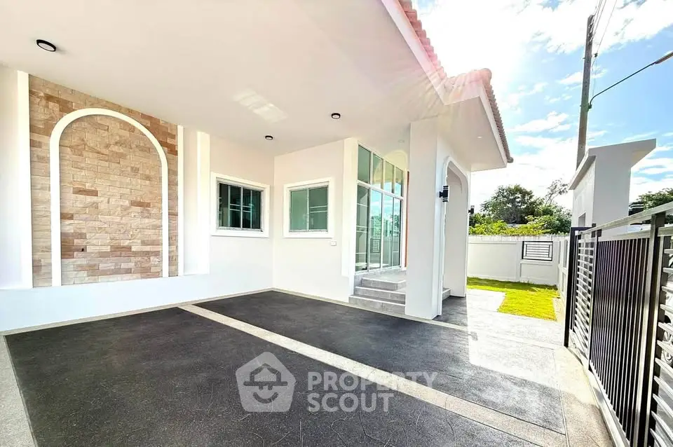 Modern house exterior with spacious driveway and elegant stone wall accents.
