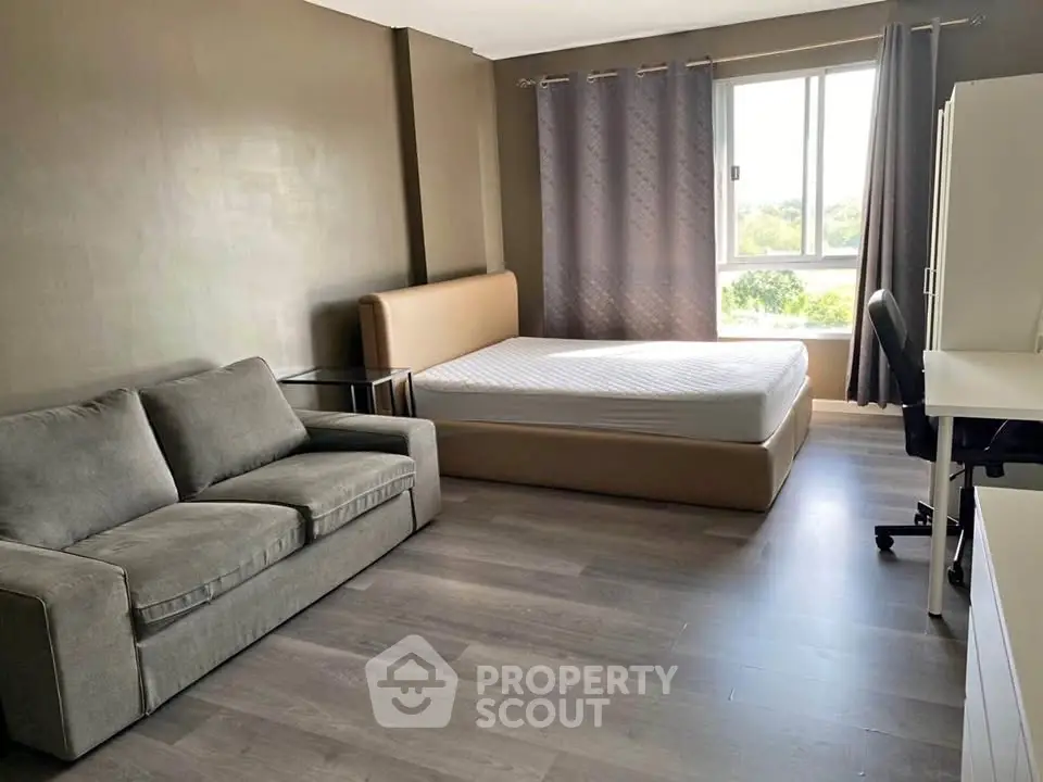 Spacious bedroom with modern furnishings and large window view