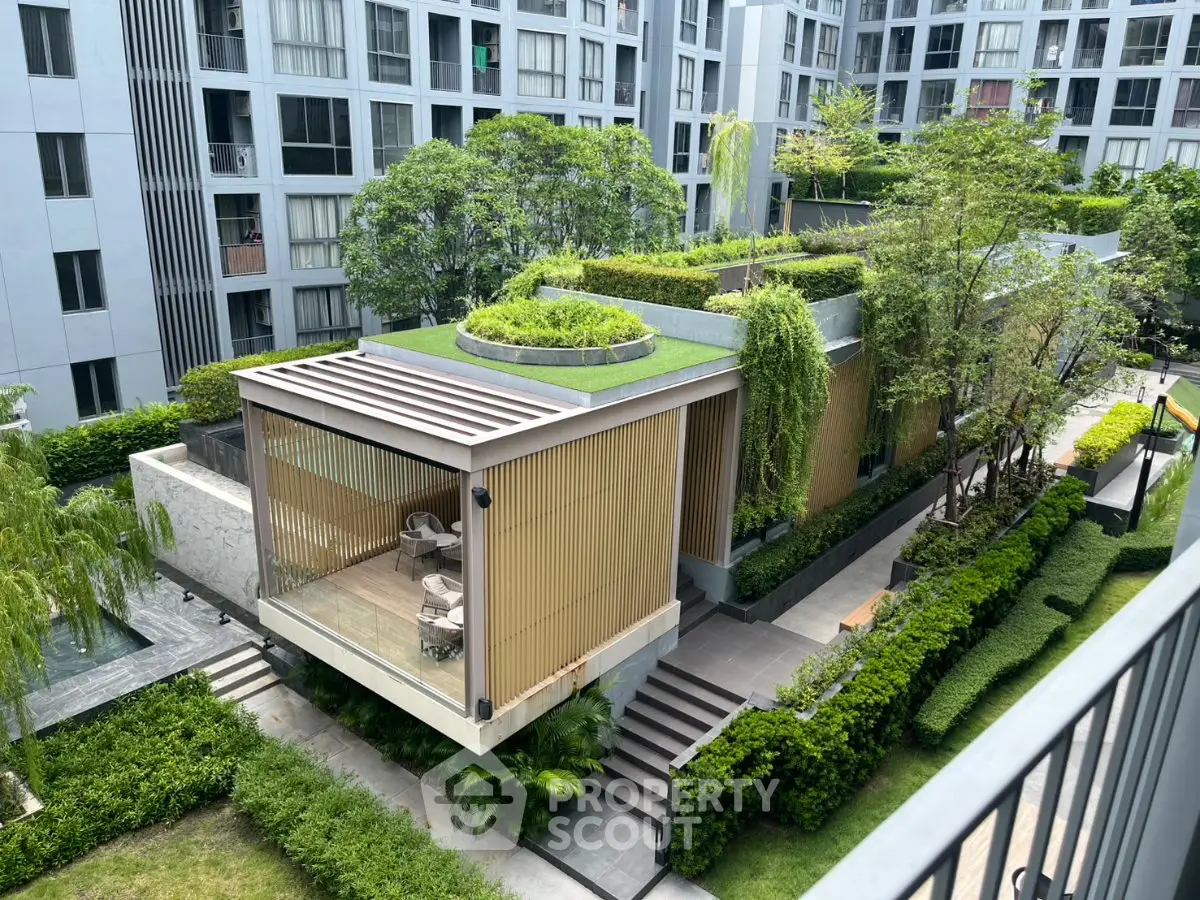 Modern building exterior with lush greenery and rooftop garden in urban setting.