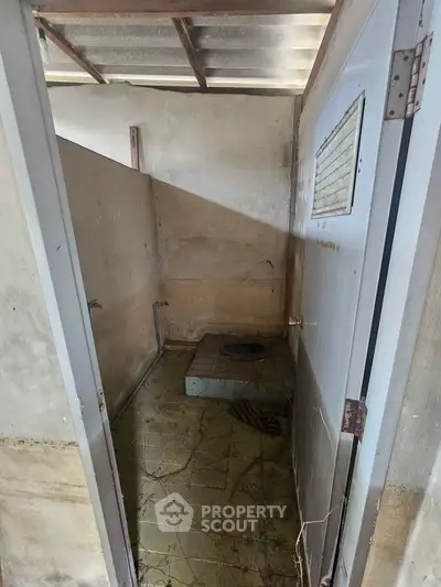 Rustic unfinished bathroom with basic amenities and natural light.