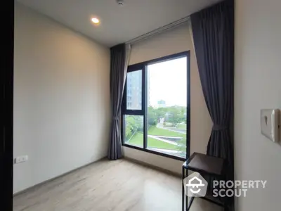 Modern empty room with large window and garden view in high-rise building