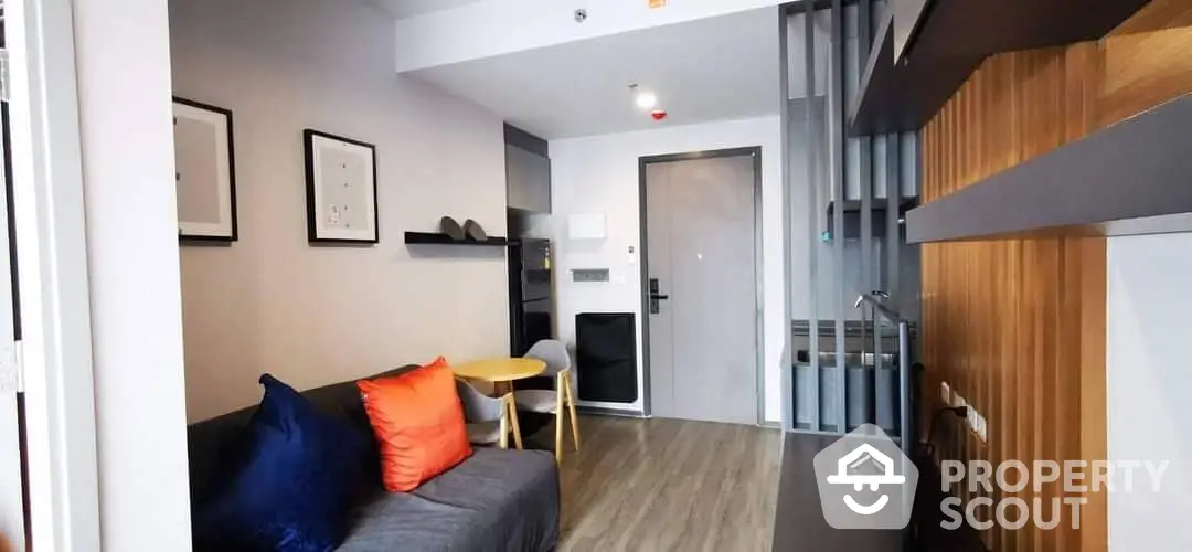 Modern studio apartment with sleek furnishings, wooden accents, and a cozy living area, perfect for urban living.