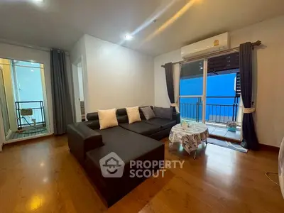 Spacious living room with modern sofa and balcony access in a stylish apartment.