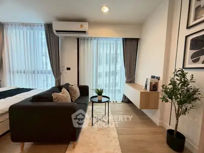 Modern living room with cozy sofa, stylish decor, and large windows for natural light.