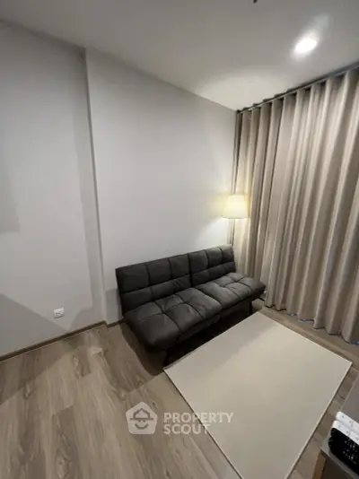 Modern living room with stylish sofa and elegant floor lamp, perfect for cozy relaxation.