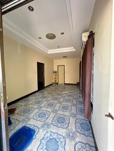Spacious empty room with tiled flooring and air conditioning, ready for customization.