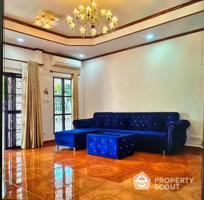 Elegant living room with plush blue sofa and chandelier lighting