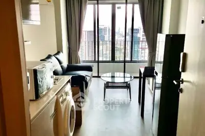 Modern living room with city view, featuring sleek furniture and washing machine.