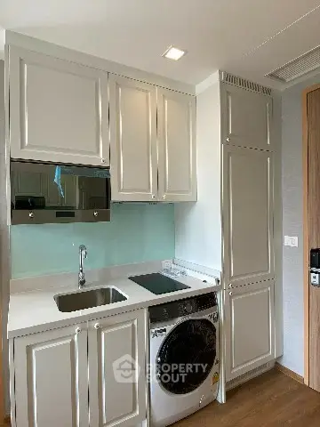 Modern kitchen with sleek cabinetry and built-in appliances in a compact layout.