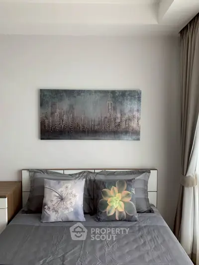 Modern bedroom with stylish decor and cityscape artwork above bed