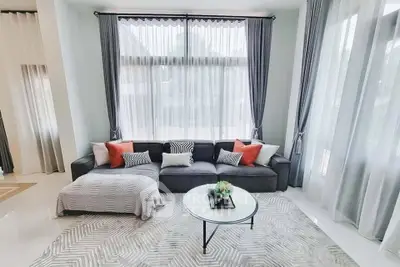 Elegant living room with large windows, stylish sofa, and modern decor in a bright, airy space.
