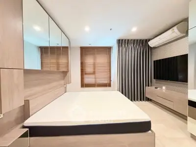Modern bedroom with sleek design, featuring a wall-mounted TV and air conditioning, perfect for comfort and style.