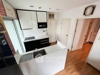 Modern kitchen with sleek cabinetry and built-in appliances in a cozy apartment.