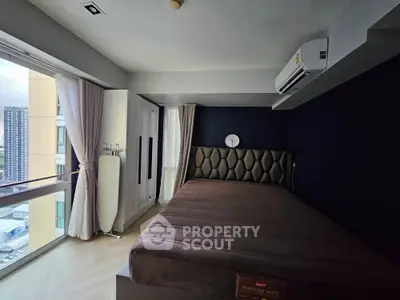 Modern bedroom with large window and city view, featuring stylish bed and air conditioning.