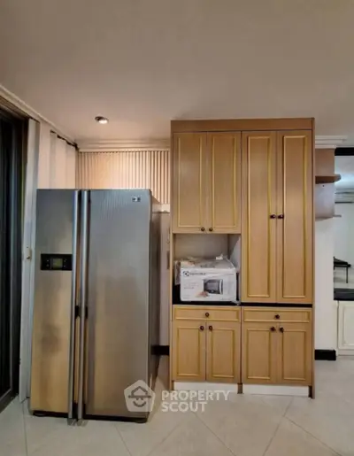 Modern kitchen with stainless steel fridge and wooden cabinets