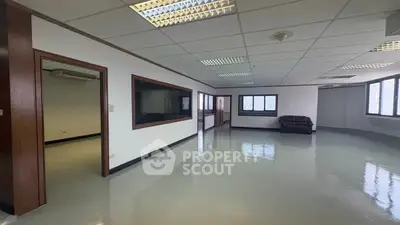 Spacious office space with polished floors and large windows for natural light.