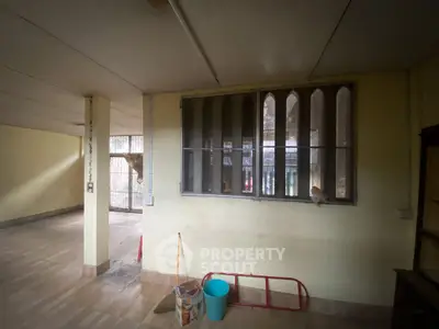 Spacious interior with large windows and open layout, ideal for renovation.