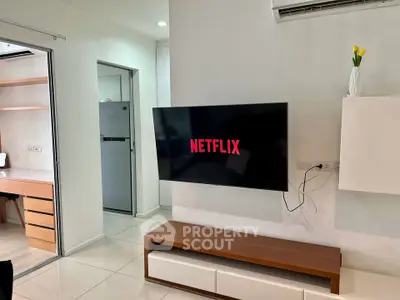 Modern living room with wall-mounted TV and sleek furniture in a stylish apartment.